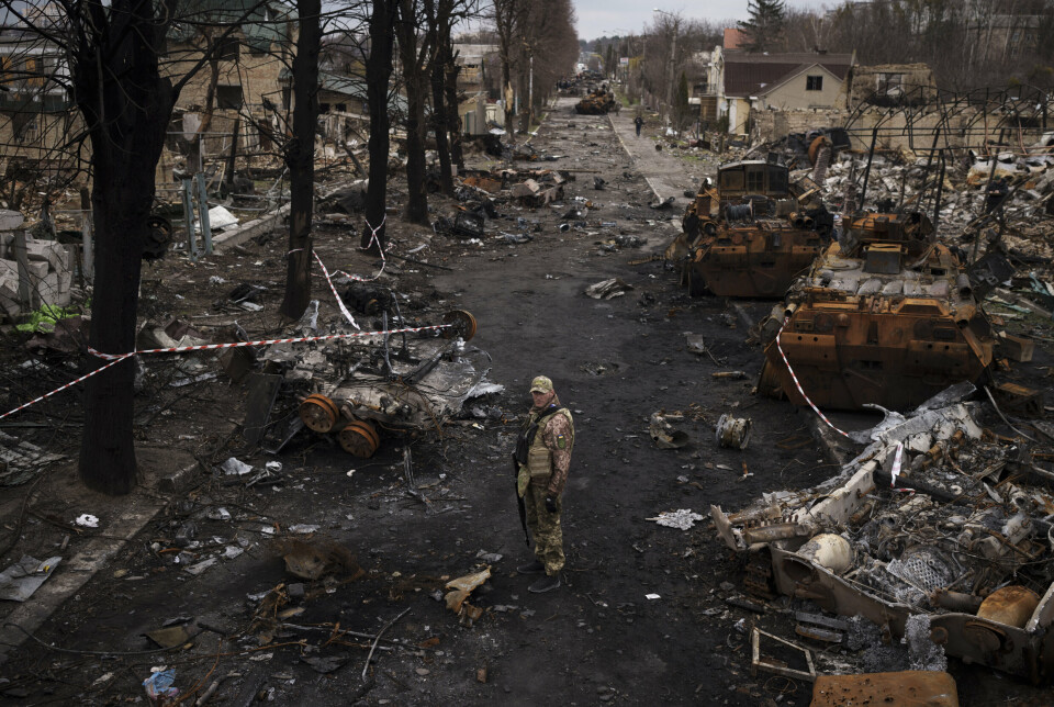 BUTSJA: En ukrainsk soldat foran ødelagte russiske stridsvogner i Butsja, byen som tidlig i krigen ble et eksempel – og et symbol – på siviles lidelser og grusomheter begått under Russlands invasjon av Ukraina.
