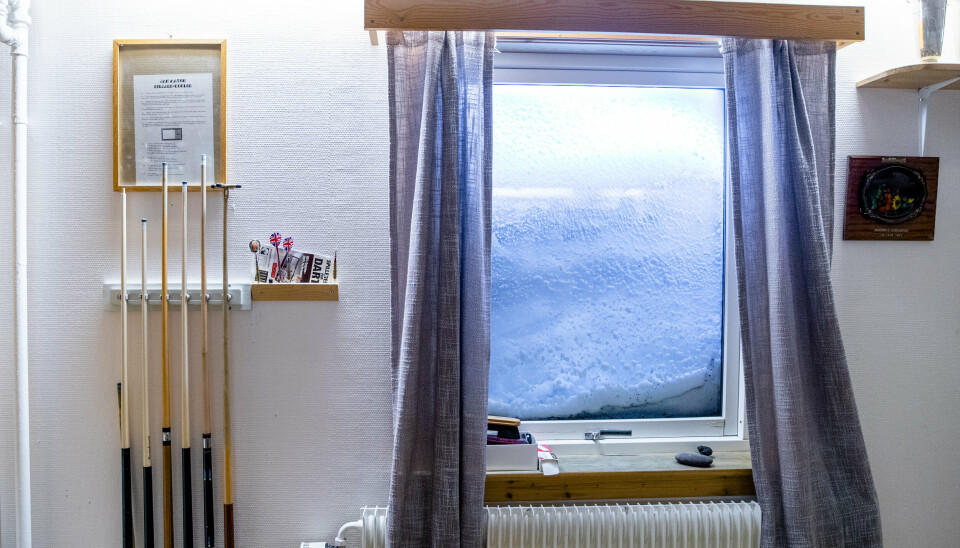 INTERIØR: Biljardkø og dartpiler ved et vindu som er dekket av snø på stasjonen i Olonkinbyen på Jan Mayen. Bildet er fra 2020.
