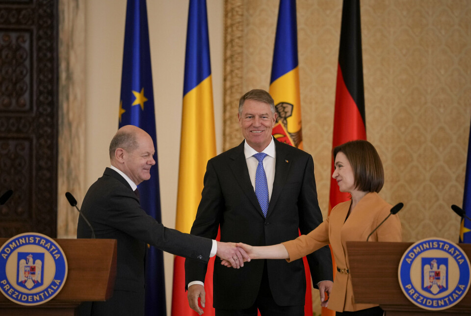 BUCURESTI: Moldovas president Maia Sandu tar Tysklands forbundskansler Olav Scholz i hånden i Bucuresti mandag kveld. I bakgrunnen står Romanias president, Klaus Iohannis.