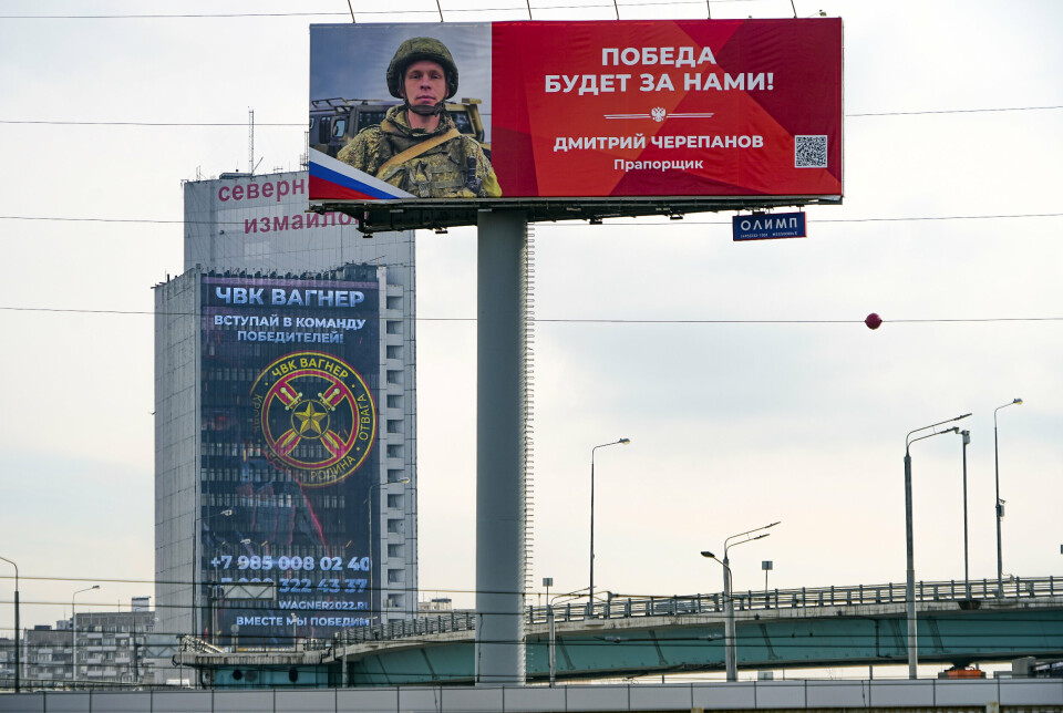 REKRUTTERER: En reklameskjerm på en bygning i den russiske hovedstaden Moskva oppfordrer til å slutte seg til Wagner-gruppen. I forgrunnen viser en annen plakat bilde av den russiske soldaten Dmitry Tsjerepanov, som er dekorert for sin innsats i Ukraina. Bildet er datert 28. mars 2023.