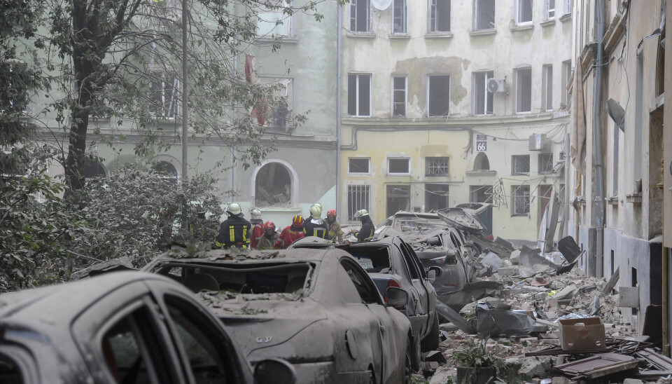 LVIV: Mannskaper fra nødetatene arbeider mellom de rammede bygningene i Lviv etter at byen ble truffet av en russisk rakett. Bildet er datert 6. juli 2023.