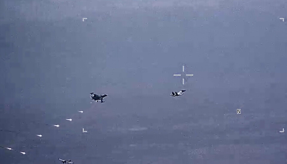 FALLSKJERMBLUSS: Dette bildet fra en video fra det amerikanske luftforsvaret viser russiske fly av typene SU-34 og SU-35 som slipper fallskjermbluss i flybanen til en amerikansk MQ-9 Reaper-drone. Dronen kan ses nede til venstre i bildet. Det er datert 6. juli.