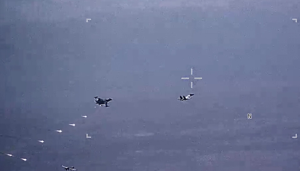 FALLSKJERMBLUSS: Dette bildet fra en video fra det amerikanske luftforsvaret viser russiske fly av typene SU-34 og SU-35 som slipper fallskjermbluss i flybanen til en amerikansk MQ-9 Reaper-drone. Dronen kan ses nede til venstre i bildet. Det er datert 6. juli.