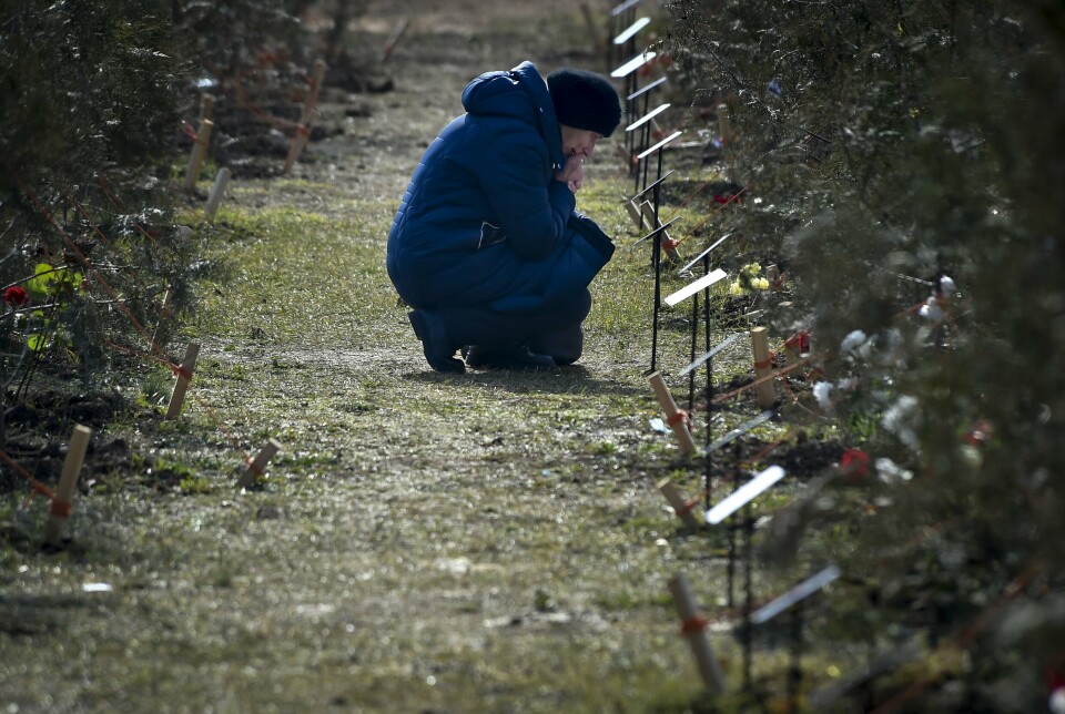 SEVASTPOL: En sørgende mor kneler ved graven til sønnen som ble drept i krigen i Ukraina. Bildet er datert 25. februar 2023. Det er åpnet en egen minnelund i Sevastpol på Krym for soldater som har mistet livet i Russlands invasjon av nabolandet.