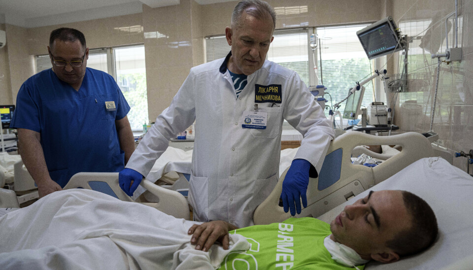 SÅRET SOLDAT: Sjeflege Serhii Ryzhenko snakker med den 22 år gamle ukrainske soldaten Oleh Halah. Han ble såret av en russisk stridsvogn nær Lyman. Mechnikov-sykehuset er blant Ukrainas største og får en strøm av sårede soldater hver dag.