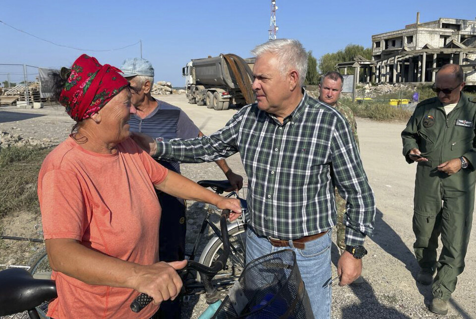 FRYKTER KRIG: Romanias forsvarsminister, Angel Tilvar snakker med en innbygger fra en landsby ved Donaudeltaet ved den ukrainske grensen i september 2023. Der ble det funnet rester av russiske droner etter Russlands angrep mot Ukrainas havn på Donau.