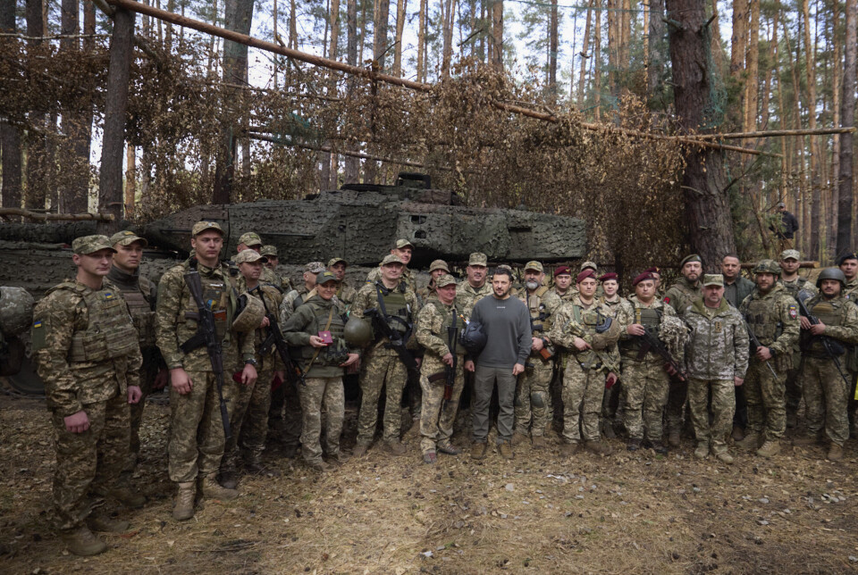 VED FRONTEN: President Volodymyr Zelenskyj sammen med ukrainske soldater i Kharkiv-regionen, øst i landet. Bildet skal være tatt 3. oktober. I bakgrunnen ser man en Leopard 2 stridsvogn.