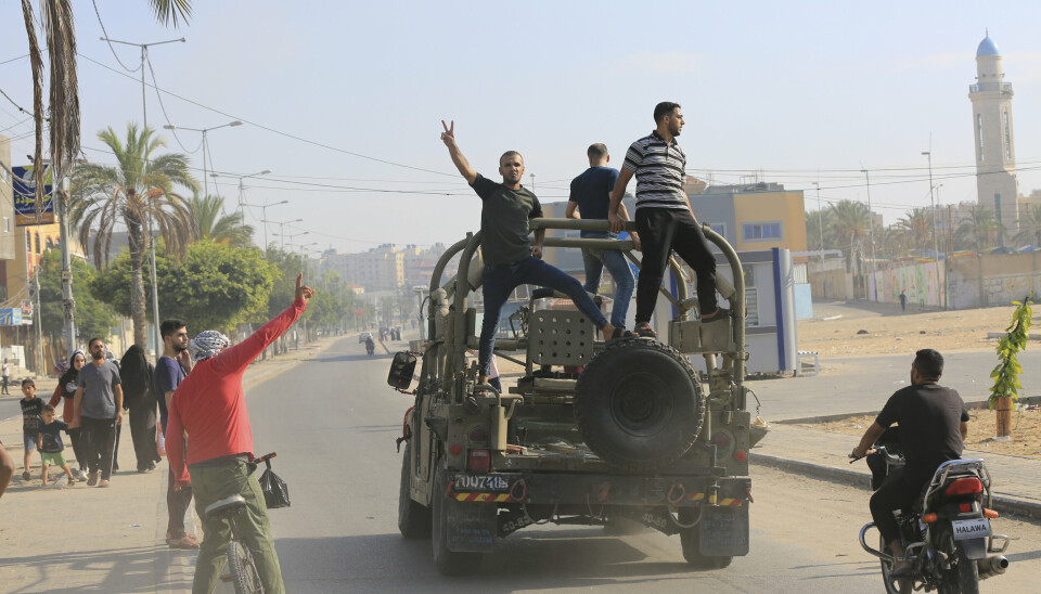 FRASTJÅLET KJØRETØY: En gruppe palestinere kjører et israelsk militærkjøretøy som ble tatt etter at Hamas-militanter kjørte inn i en hærbase tilhørende IDF. Bildet er tatt 7. oktober 2023.