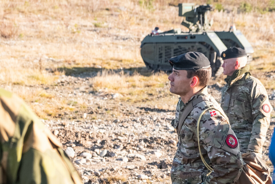 Danske soldater foran en UGV (Unmanned ground vehicle) som ser på CV90.