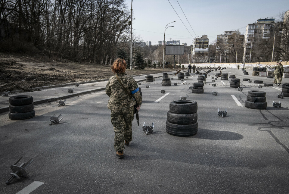SPANSKE RYTTERE: Ukrainske soldater vokter en av innfartsårene i Kyiv i mars 2022, rundt 15 kilometer fra kamphandlingene i Irpin. Forsvarsverkene består både av sammensveiste stålbjelker, såkalte spanske ryttere, for å stanse stridsvogner, murblokker, skyttergraver og miner.
