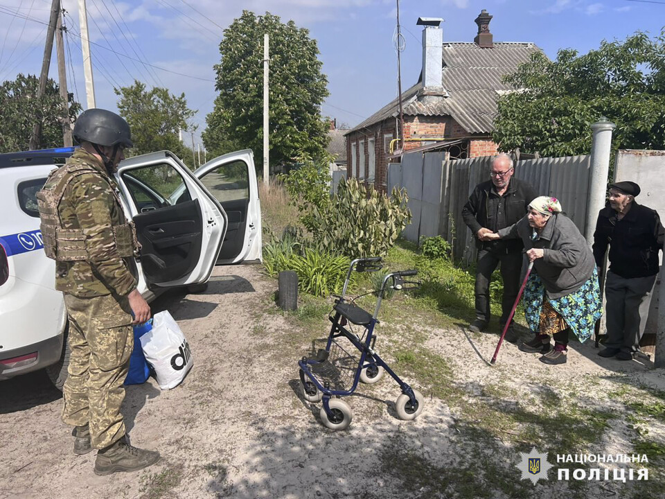 HJELPER: Politiet hjelper en eldre kvinne å flykte fra Kharkiv. Russland startet fredag en offensiv i regionen.