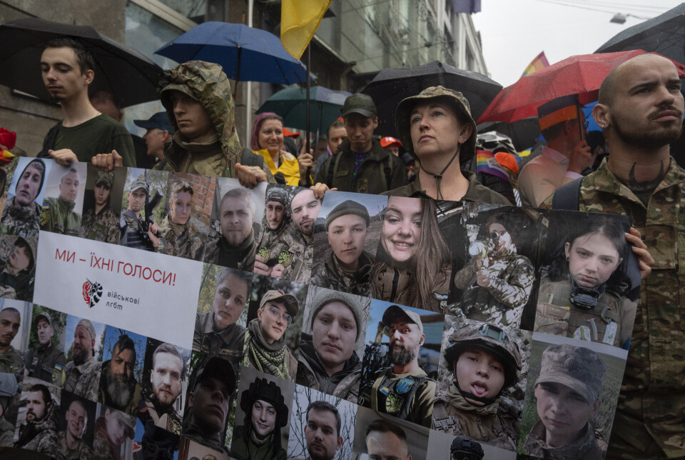 «VI ER DERES STEMMER»: Soldater holder opp portretter av ukrainske LHBT-medsoldater som kjemper ved fronten under søndagens prideparade i Kyiv.