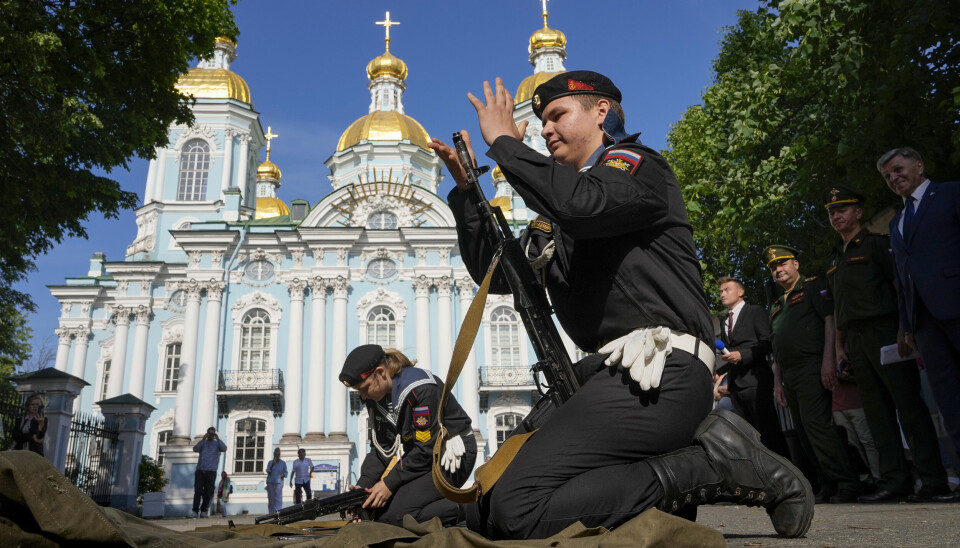 FARVEL: Medlemmer av en sjømilitær ungdomsklubb driller med kalasjinikover under et arrangement i nærheten av St. Nikolas-katedralen i St. Petersburg. Markeringen er for russiske rekrutter på vei til avdelingene sine for ett års obligatorisk tjeneste.Her fra 4. juni 2024.