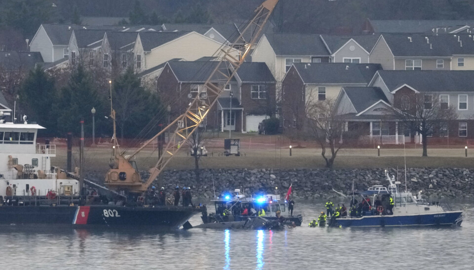 HAVARI: Et fartøy fra den amerikanske kystvakten og dykkere jobber rundt helikopterskroget i elven Potomac, fredag 31. januar.