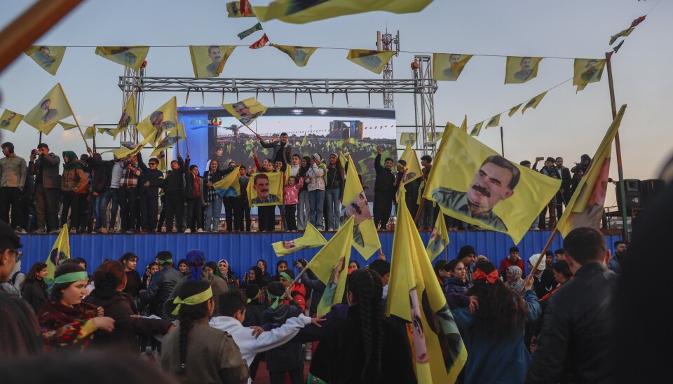 Kurdiske innbyggere vifter med flagg av Abdullah Öcalan under en samling i Qamishl.