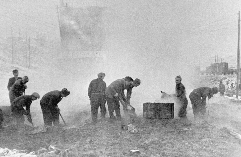 BRANN: Frigjøringen av Finnmark oktober 1944. Før tyskerne trakk seg tilbake fra Kirkenes og Sør-Varanger, satte de fyr på kullageret til A/S Sydvaranger. Lokalbefolkningen prøvde å slukke brannen, men klarte det ikke. Bildet viser frivillige som arbeider i den brennende kullhaugen.