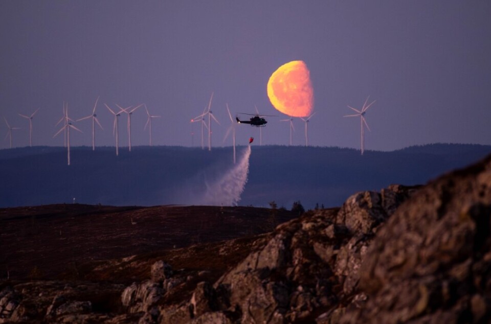 BRANNSLUKNING: Forsvarets Bell-helikopter måtte rekvireres fra Rygge for å slukke brannen inne i rød sone. Her er helikopteret i aksjon i 22.30-tiden søndag kveld.