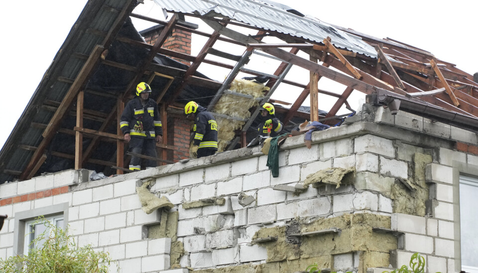 Brannvesenet står ved et ødelagt tak etter at flere droner traff det i Wyryki i Polen torsdag.