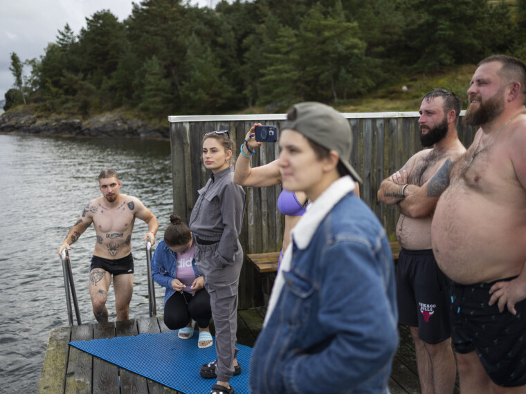 BRYGGELIV: Brygga utenfor Lilla Brattöns badstue er folksom, med badstubadere, stupere og tilskuere til dem som prøver seg på elektriske surfebrett.
