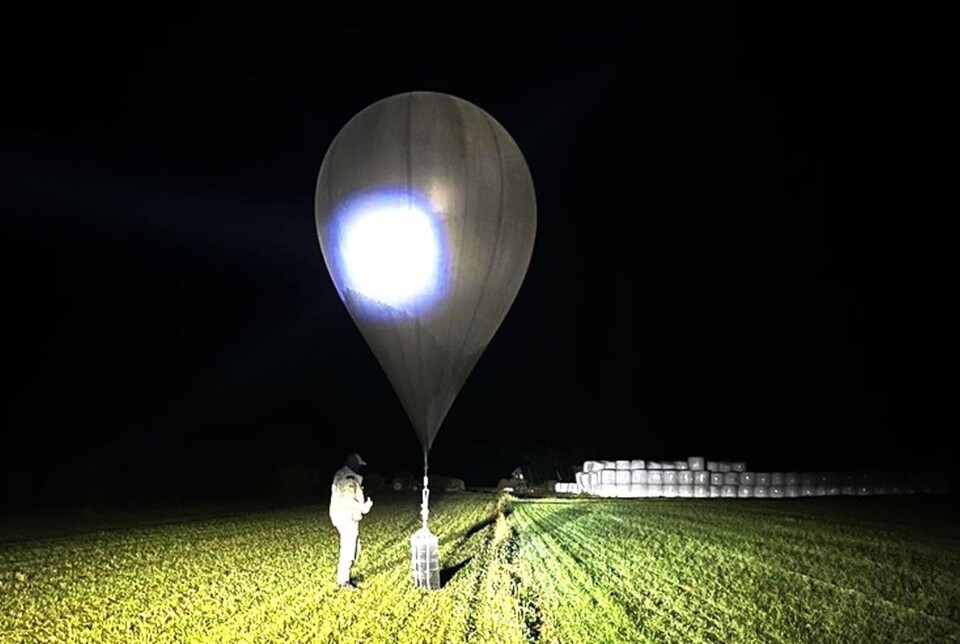 SMUGLER-BALLONG: Et udatert bilde fra Litauens grensevakt viser en tjenestemann som inspiserer en ballong brukt til å frakte sigaretter inn i landet. Smuglere fra Belarus bruker ofte slike ballonger til å sende varer ulovlig inn i EU.